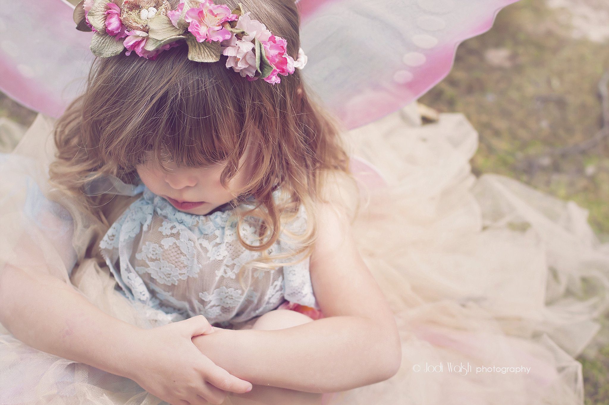 little girl pouting in her fairy dress with flower crown