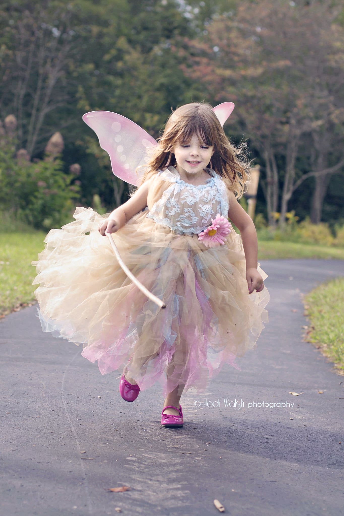 little girl in a fairy dress, running in park