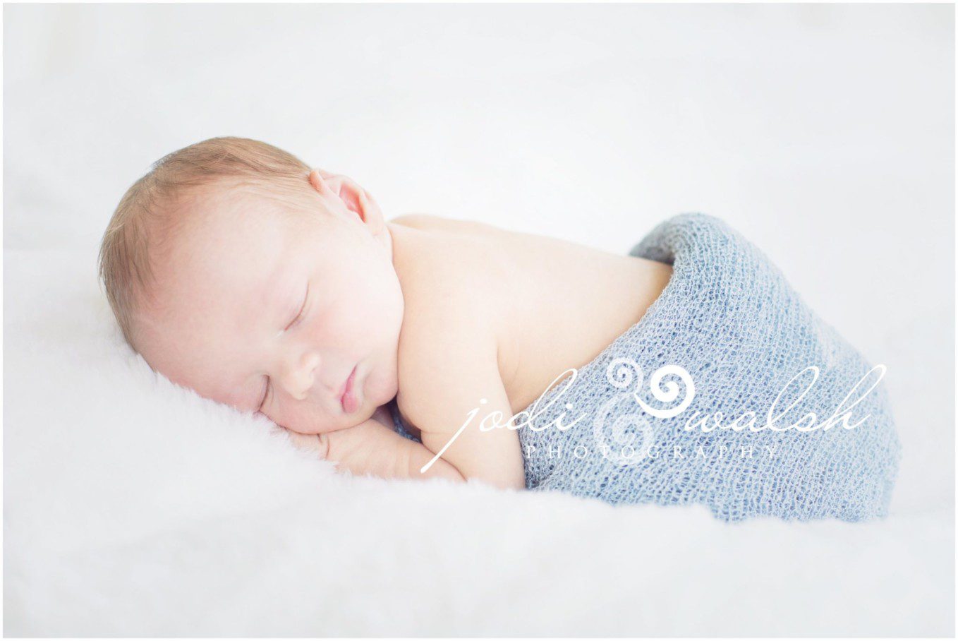 newborn baby boy sleeping in light blue wrap
