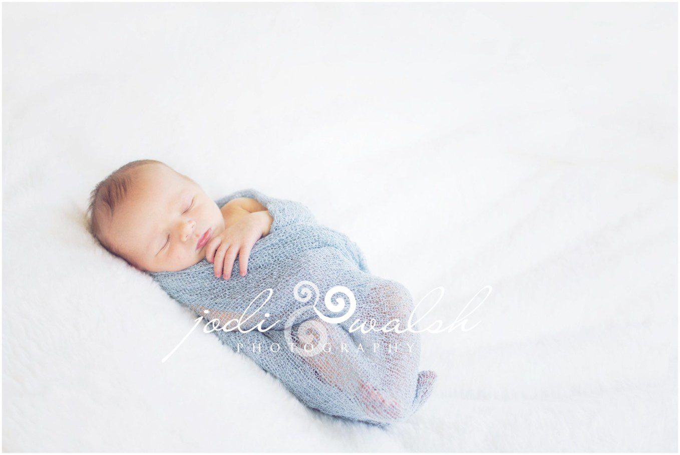 newborn boy in light blue wrap, sleeping