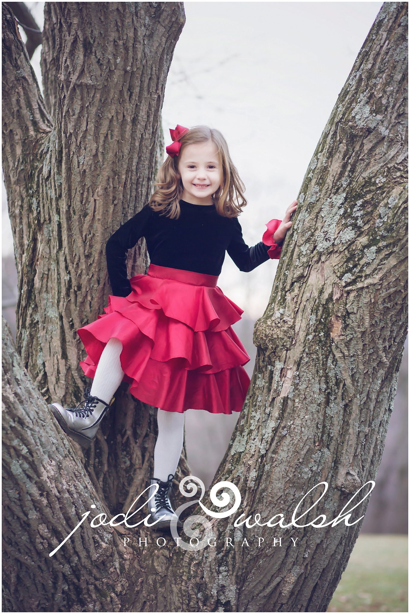child photography, little girl climbing a tree, red and black dress, silver boots, 