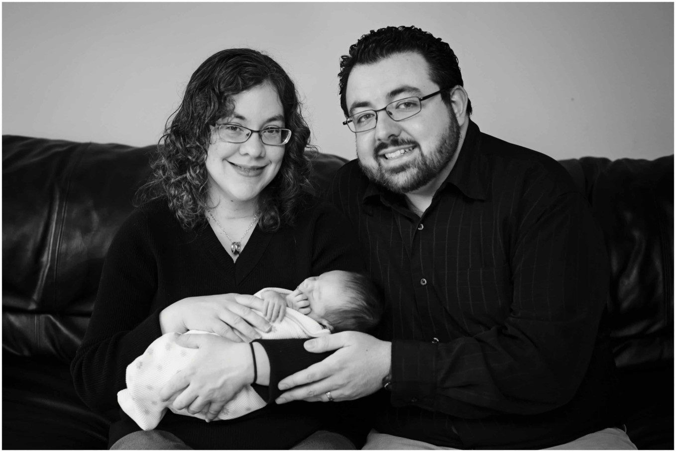 sleeping newborn in blanket with mom and dad, black and white, newborn photo session