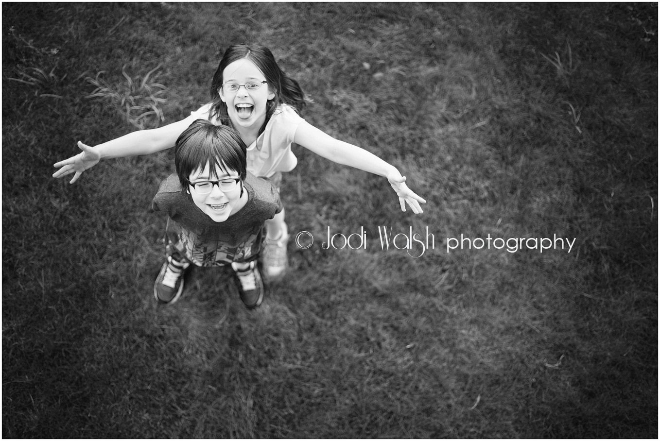 young boy and girl smiling from above in black and white
