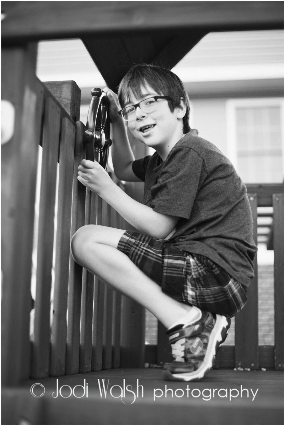 young boy in a playhouse in black and white