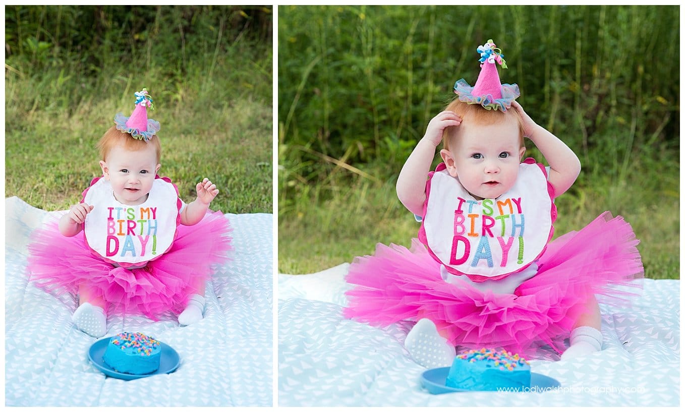 image of a baby girl in a bright pink tutu and birthday hat enjoying her cake smash session in South Park
