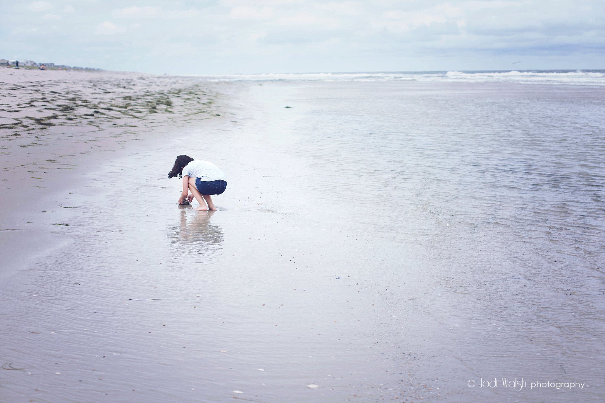 girl looking for seashells at the shore, Long Beach Island