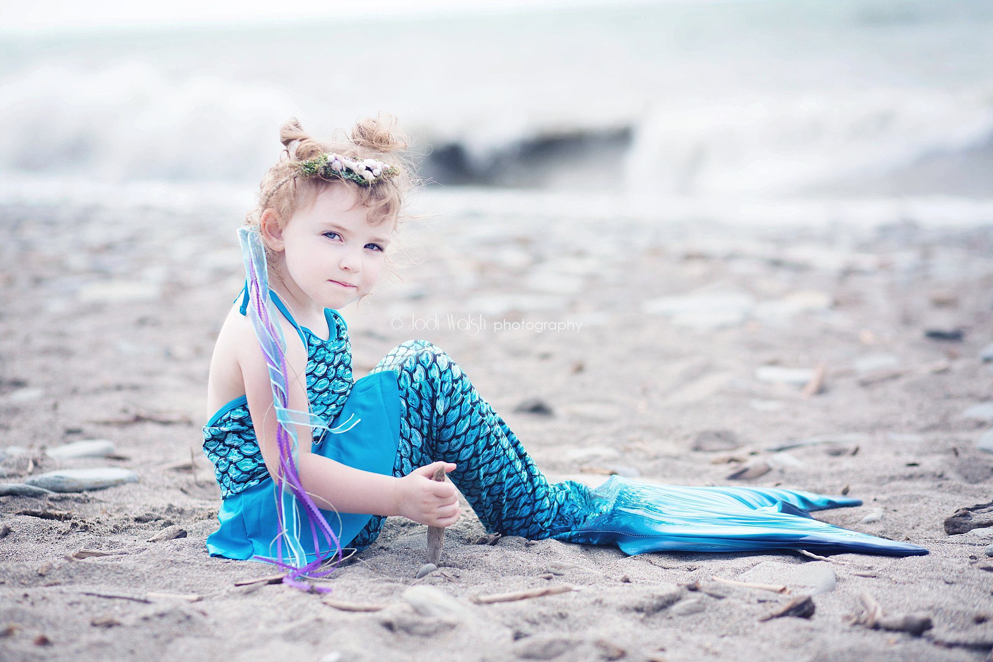 toddler girl in blue mermaid costume on the shore of Lake Erie