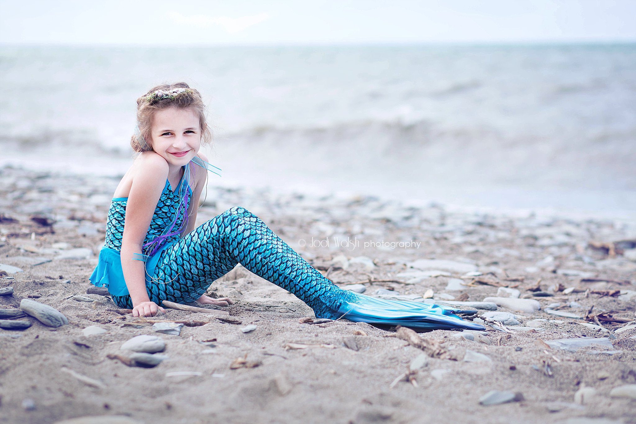 girl in blue mermaid costume on the shore of Lake Erie