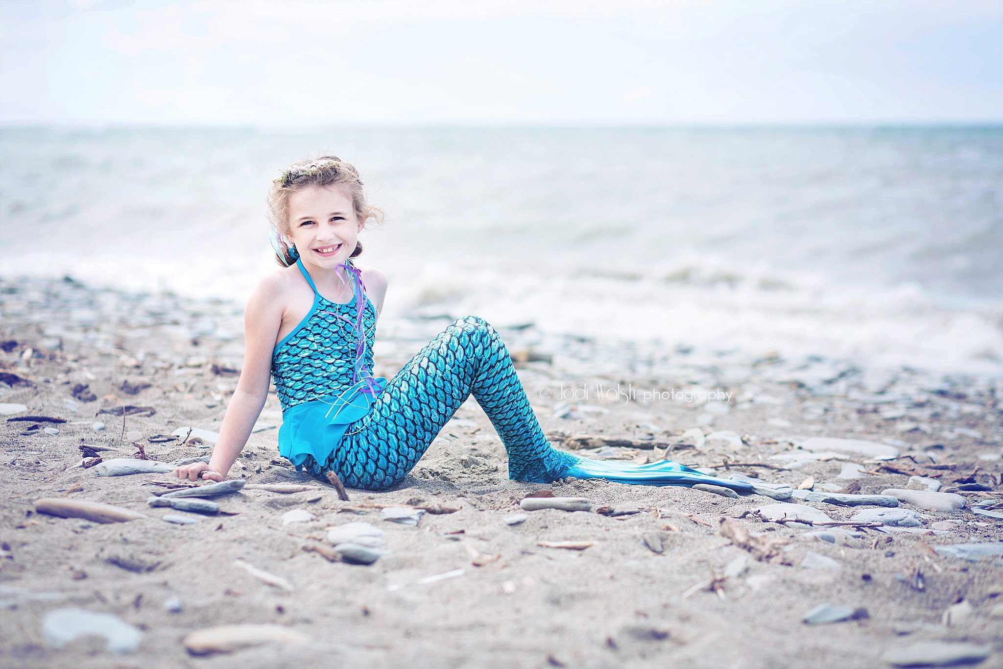 girl in blue mermaid costume on the shore of Lake Erie