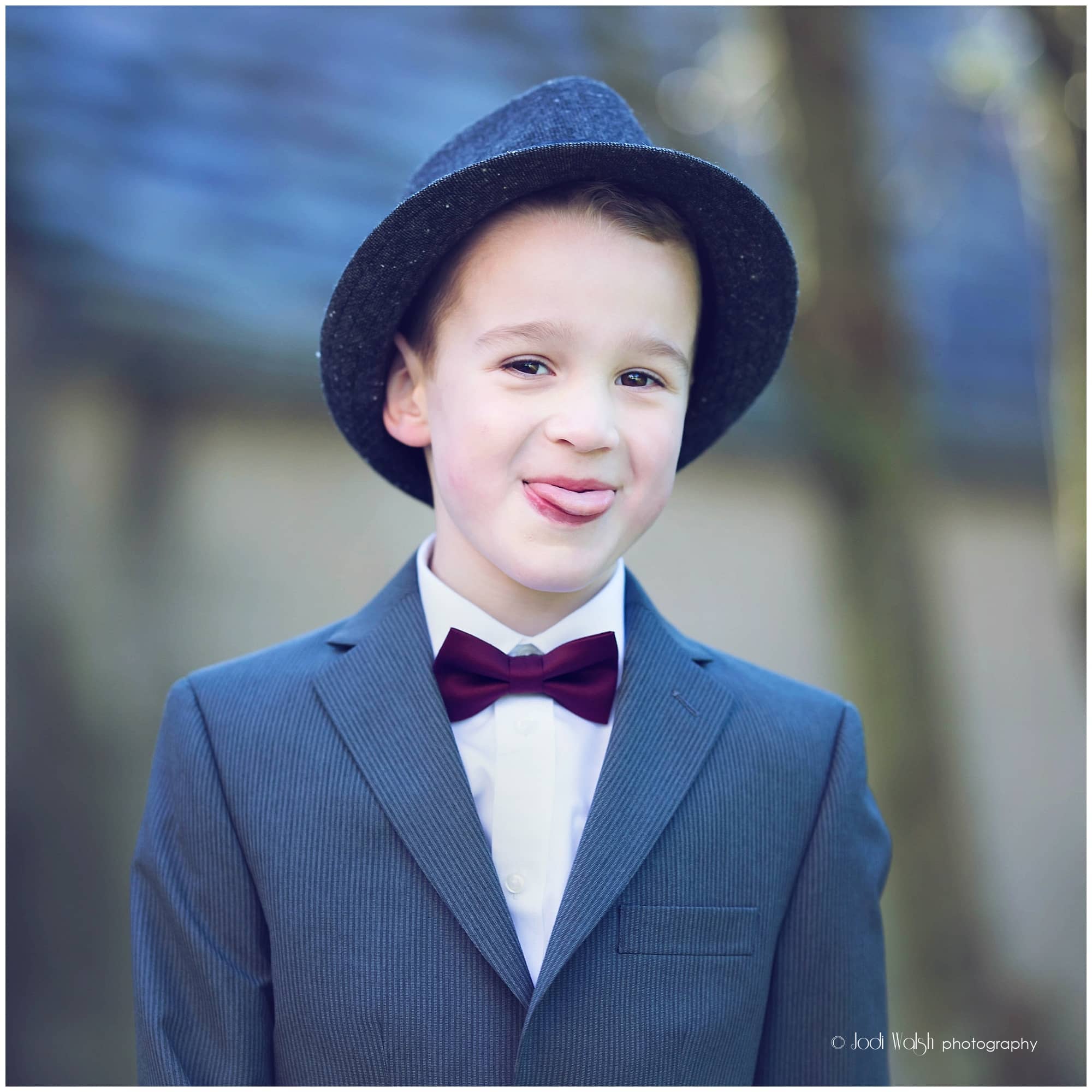 boy in a suit and bow tie sticking out his tongue
