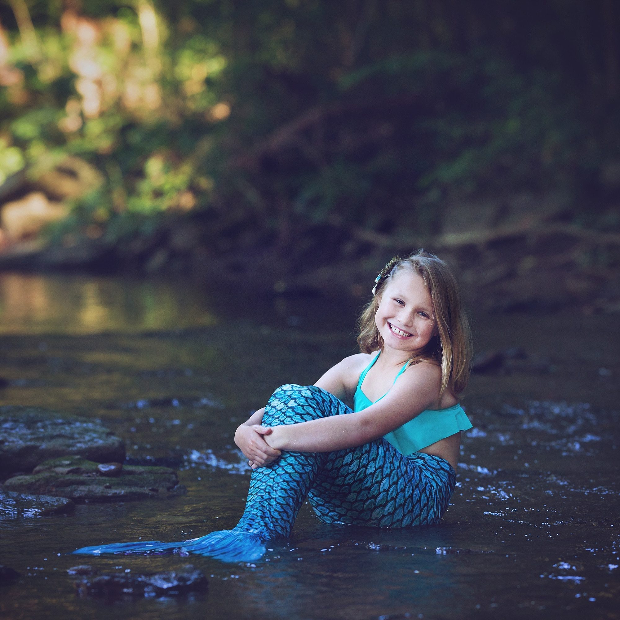 girl sitting with mermaid tail in Pittsburgh creek