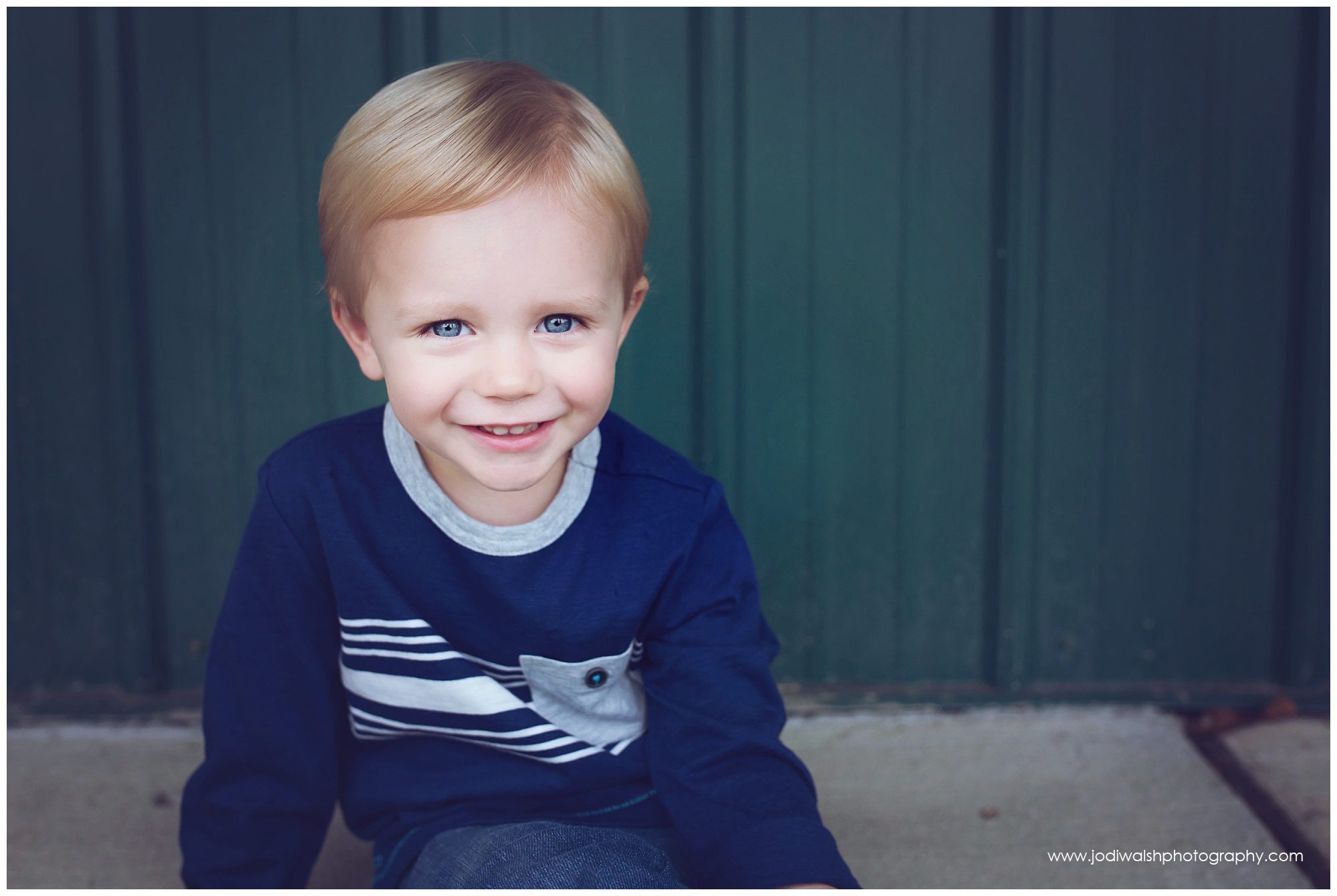 toddler boy grinning in blue shirt