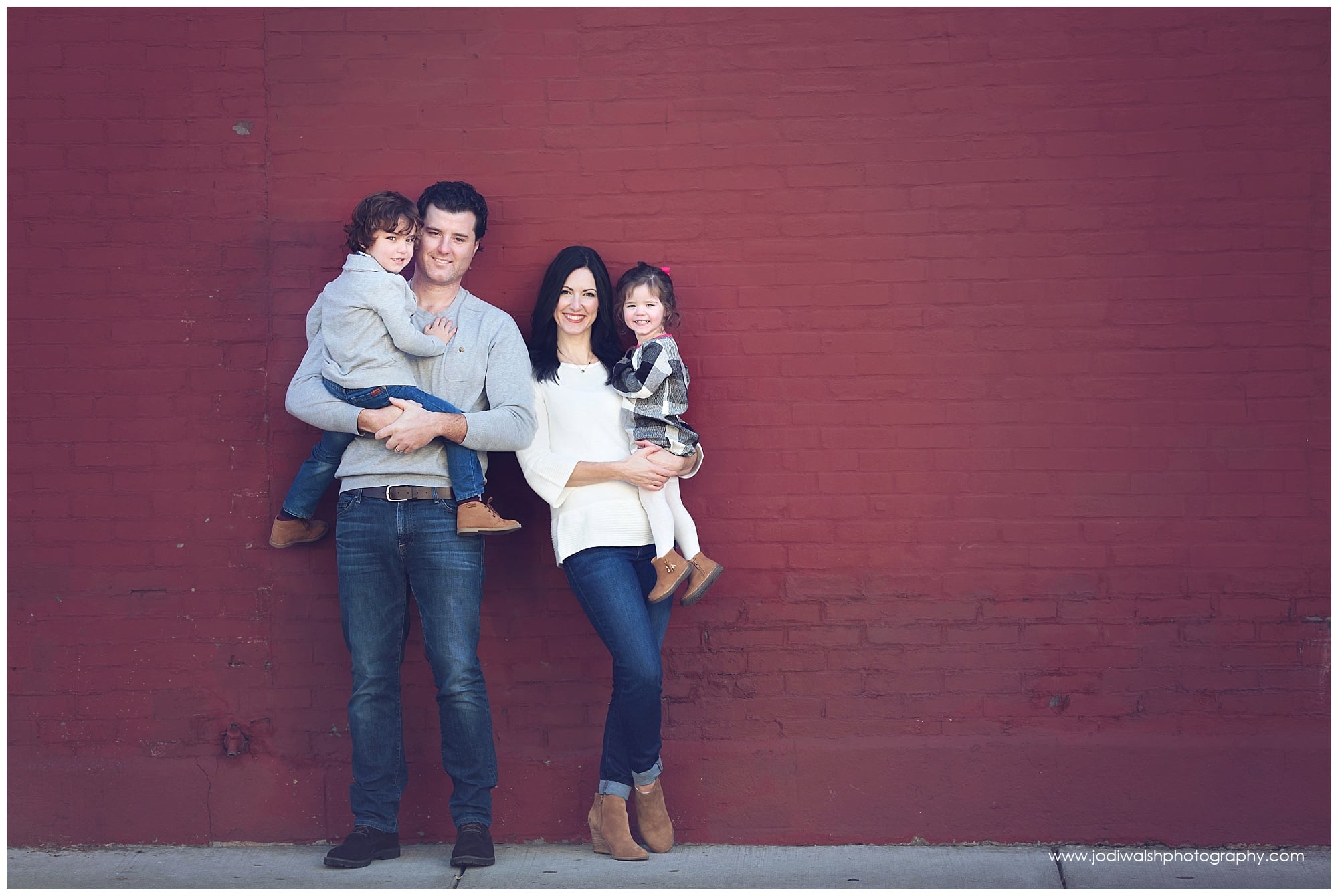 family portrait against a red brick wall