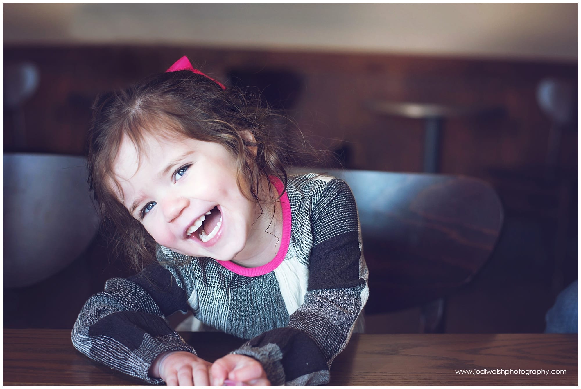 little girl with big grin in coffee shop