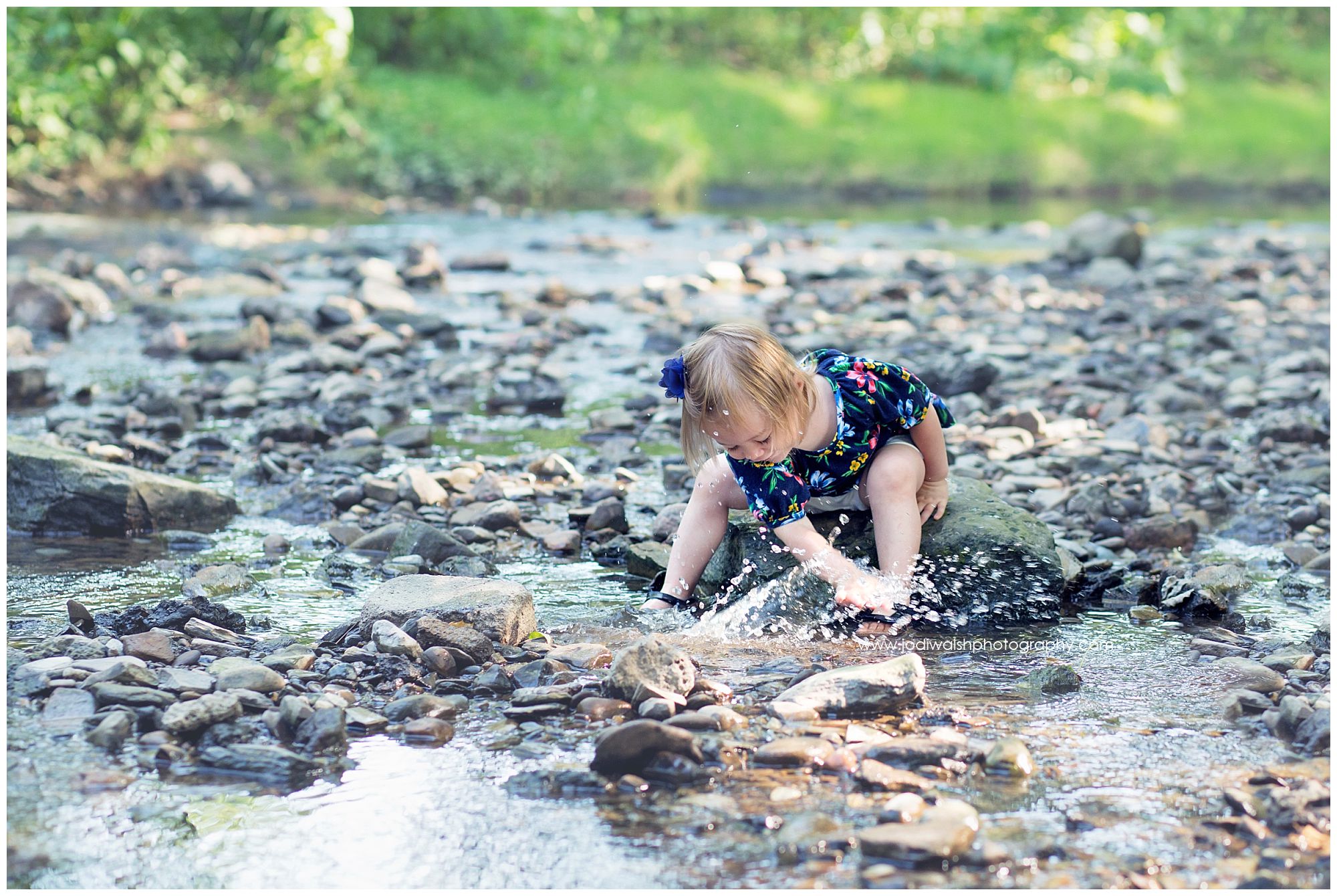 little girl splashing in Erie creek in summer
