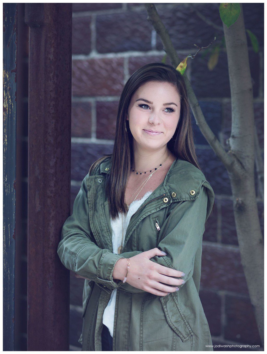 small-town senior portrait session in Sewickley.  Image of a senior girl wearing a green cargo jacket, standing in a doorway