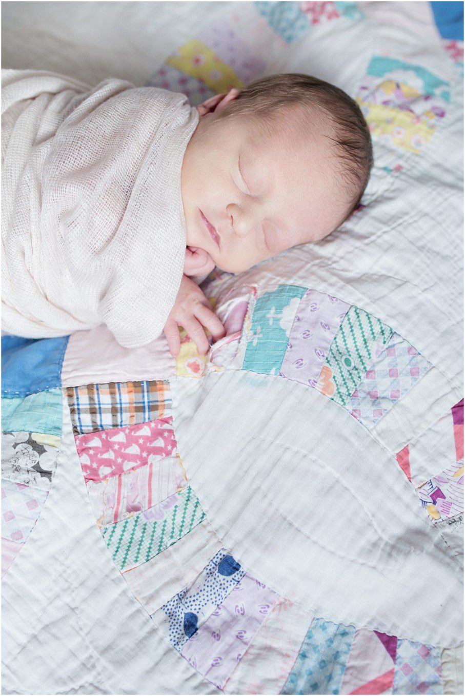 newborn baby girl in pink wrap sleeping on patchwork quilt, Pittsburgh