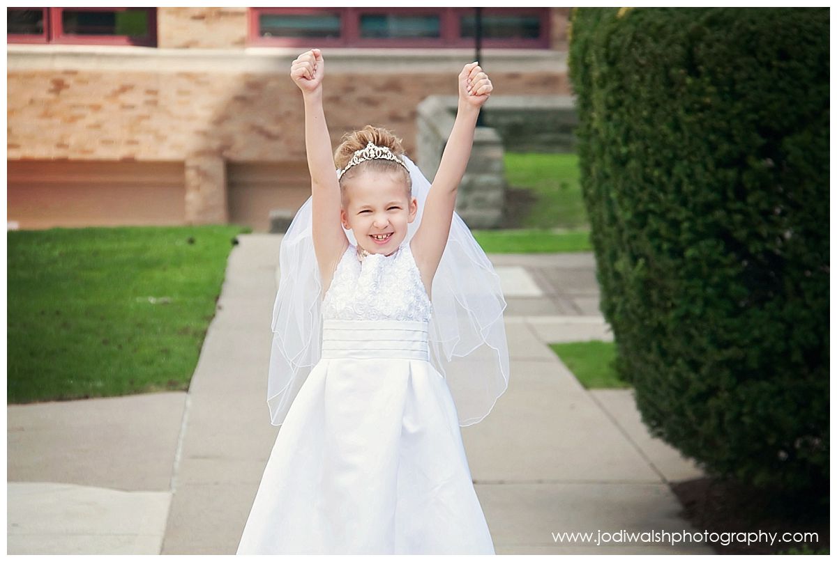 little girl with hands in the air celebrating her first holy communion outside Sacred Heart Church, pittsburgh