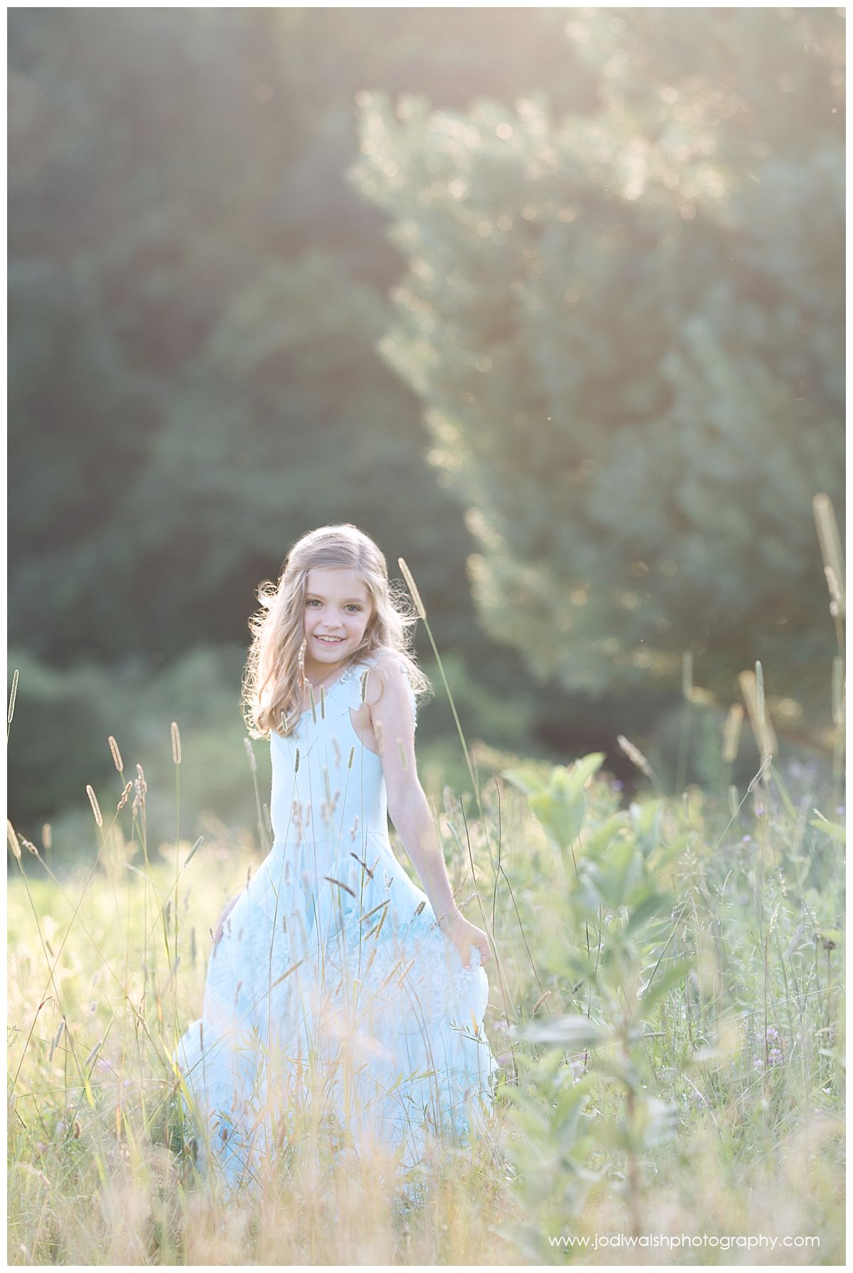little girl wearing a blue flowy dress in grassy field locations