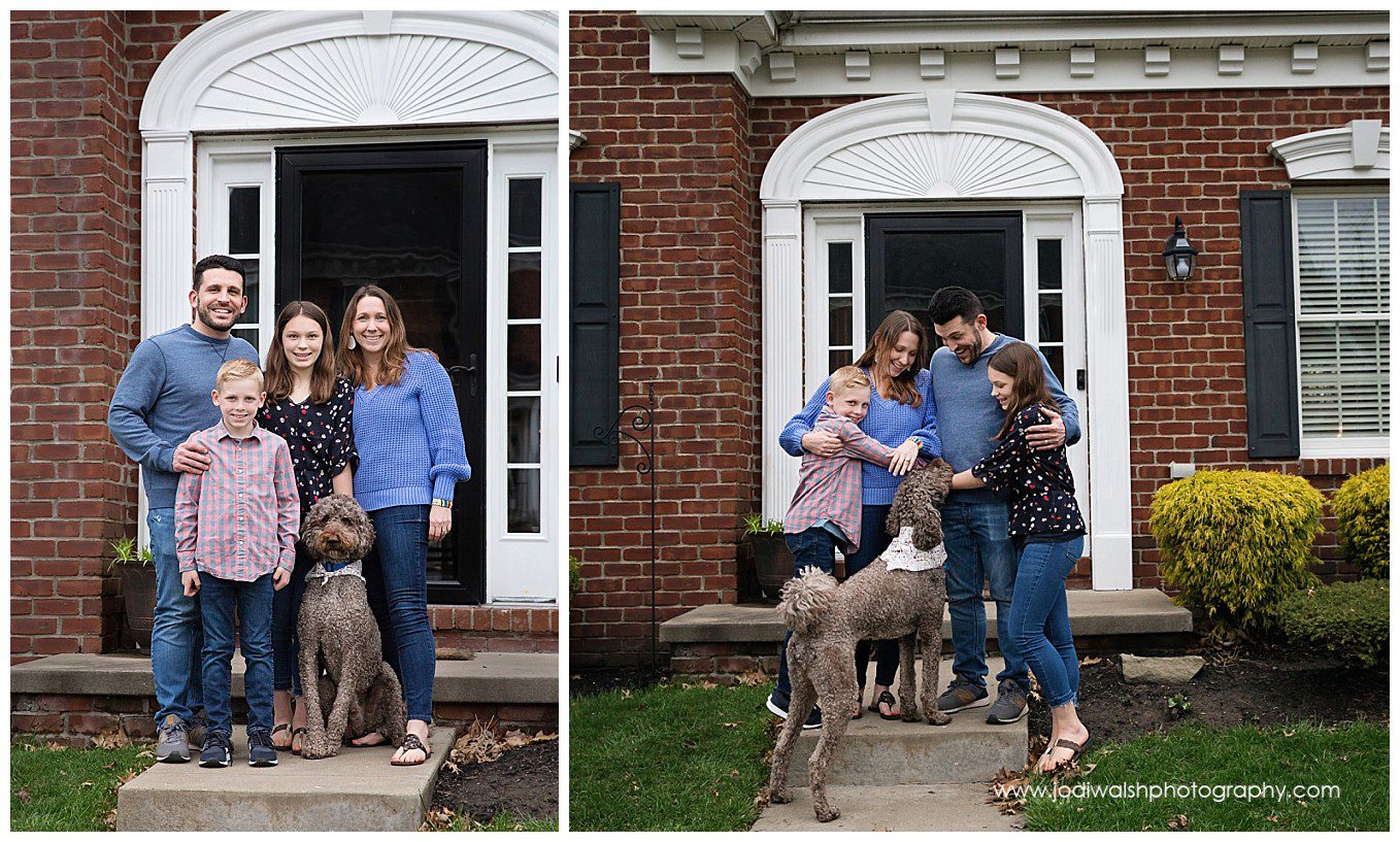 image of a family standing on their front porch in Pittsburgh. Mom and Dad are wearing blue. Older sister is in the middle, wearing black while younger brother is in front of dad and wearing a striped button-down shirt. They also have a brown labra-doodle sitting with them.