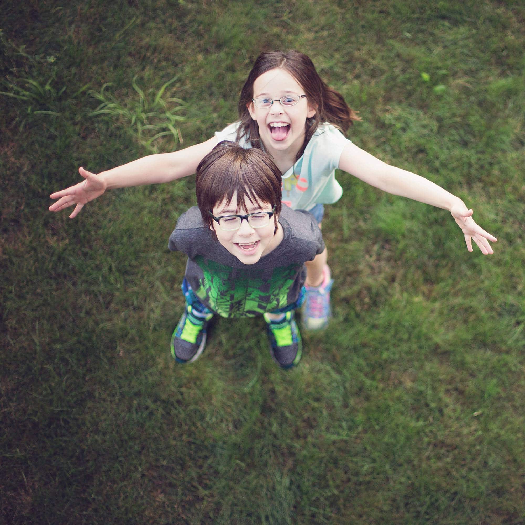 image from above looking down at boy and girl standing in the grass and smiling