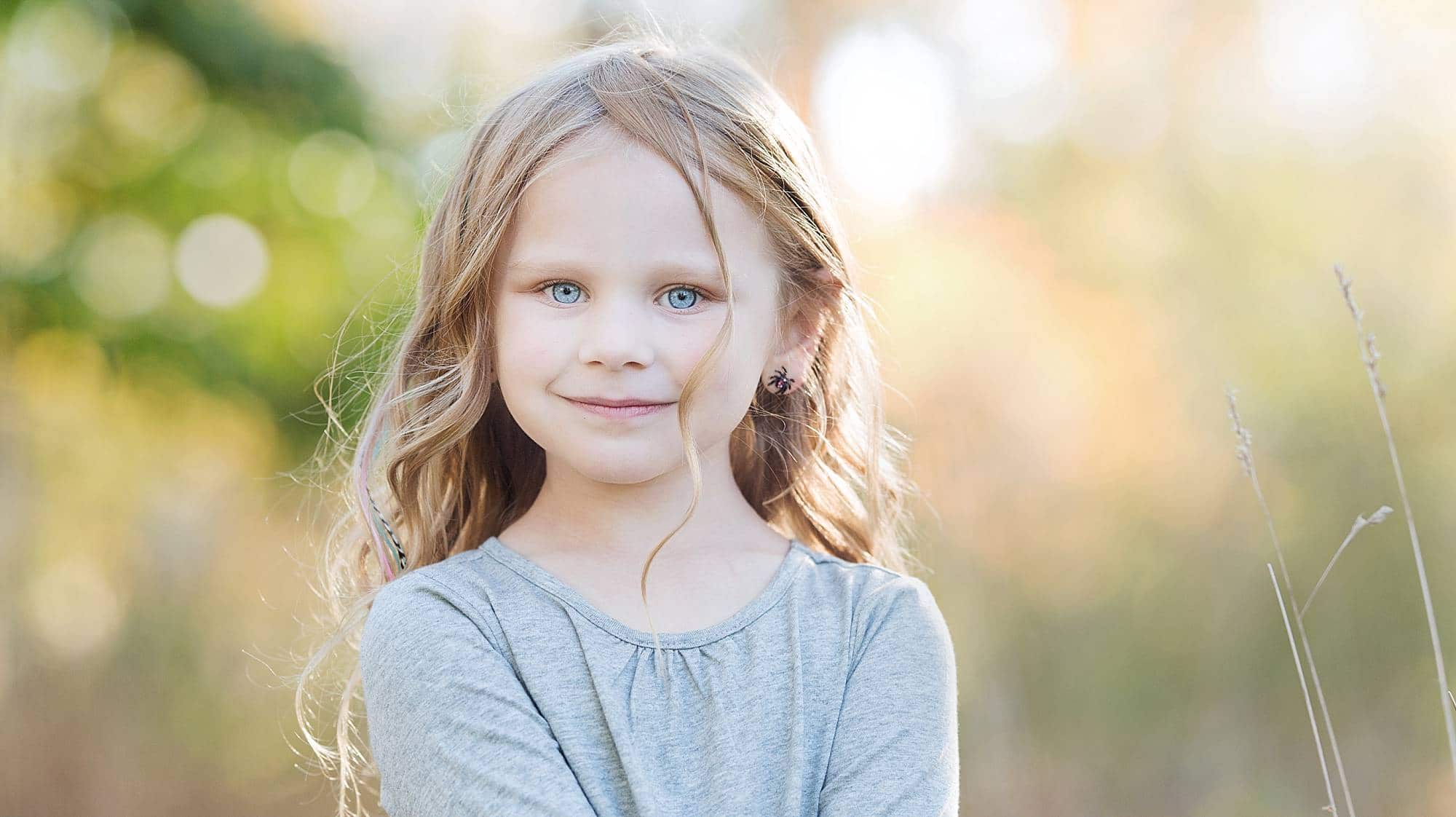 closeup image of a little girl with blond wavy hair and bright blue eyes