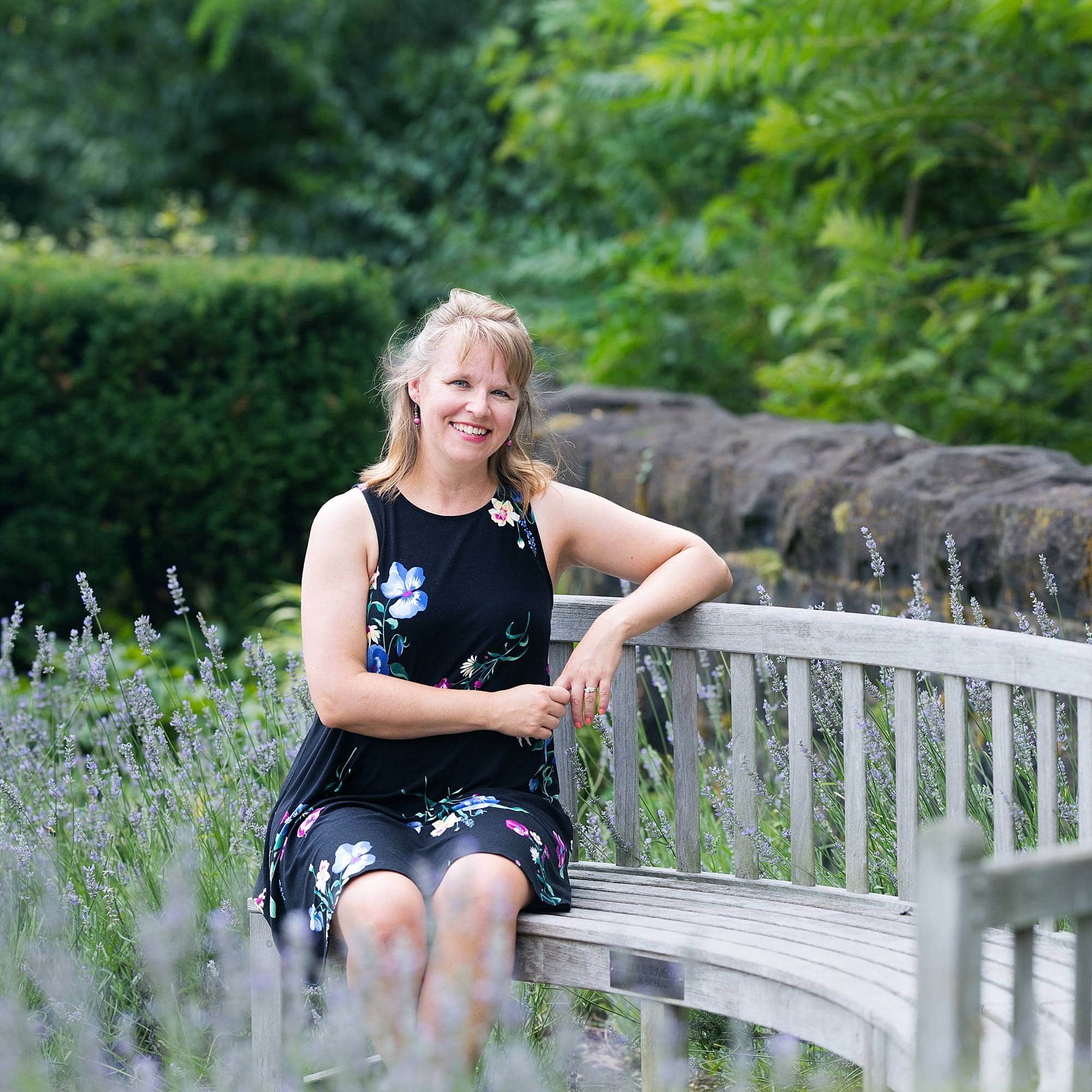 image of a woman sitting on a wooden bench in a garden in Schenley Park