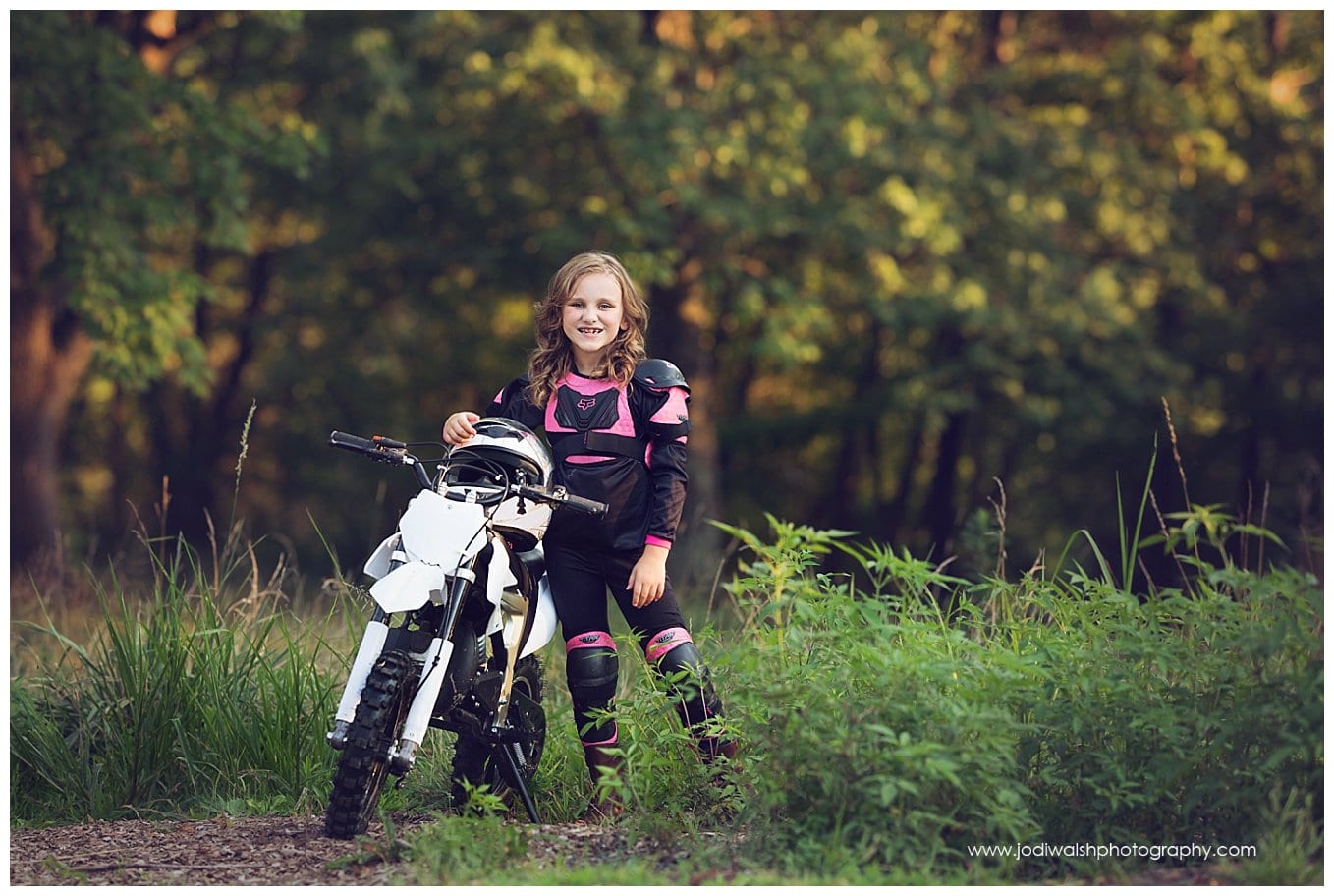 image of a little girl wearing black and pink racing gear, standing next to her white dirt bike in South Park.