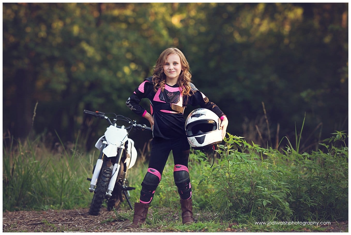 image of a little girl in black and pink racing gear, standing next to her white dirt bike in South Park.