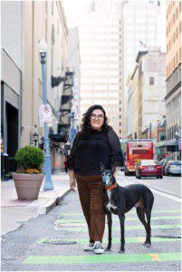 image of a senior girl with her dog. They're standing on Penn Ave in downtown Pittsburgh.