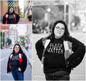 images of a senior girl standing on a downtown Pittsburgh street. She has dark wavy hair and glasses and she's wearing a black lives matter shirt.