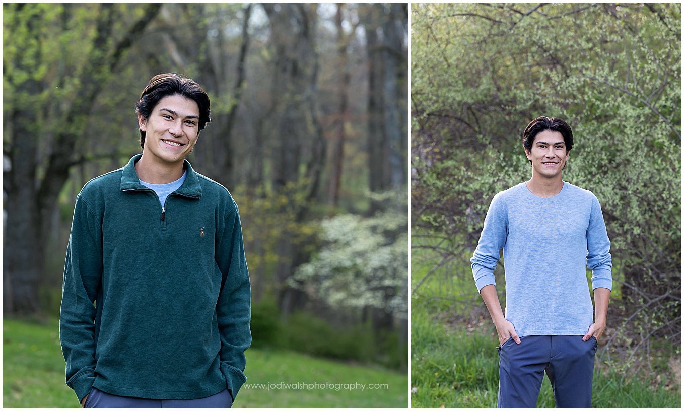 images of senior guy taken in the spring.  He's wearing a long sleeve dark green shirt in the first image.  He's standing in a clearing with a path into the woods behind him.  In the second image, he's wearing a light blue sweater and is standing in front of a tall tree with tiny white flowers.