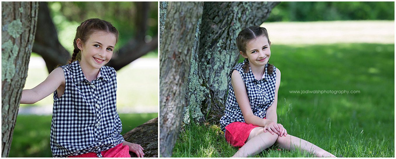 image of a little girl in a checked sleeaveless blouse and red shorts. She's sitting next to a tree in the shade at Moraine State Park near Pittsburgh