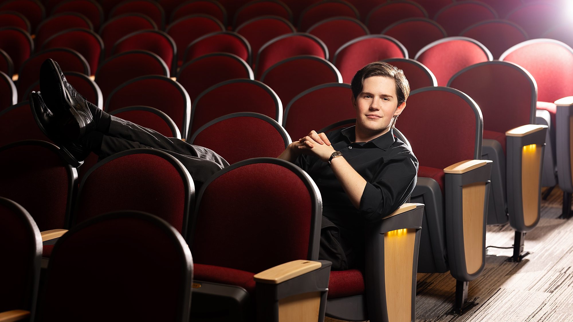 high school senior guy, relaxing in the seats of Avonworth auditorium. 
