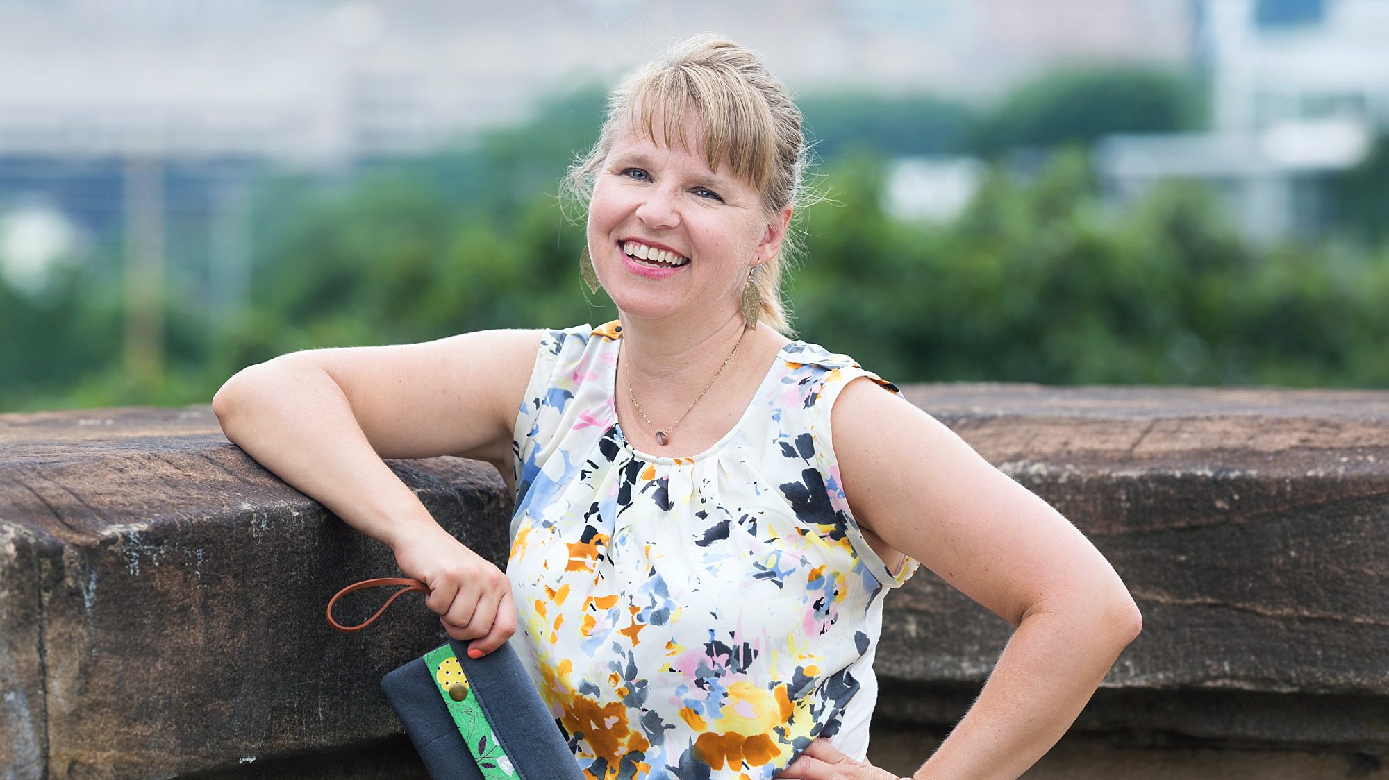 Naptime Inspirations creator, Theresa Grosh and one of her purses as she stands on Panther Hollow Bridge in Pittsburgh